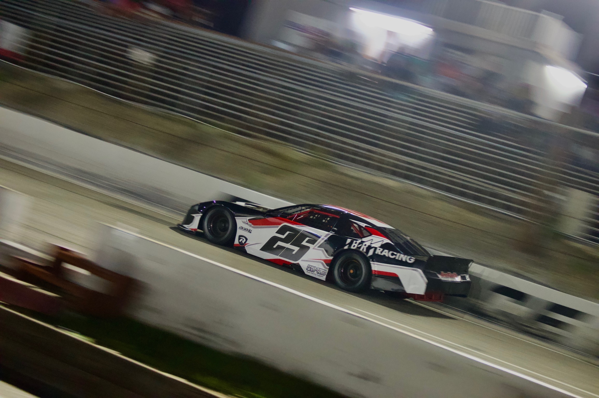 The No. 25 Queen City Garage Limited Late Model races wheel-to-wheel with the No. 70 Coastal Marine car under the lights at Florence Motor Speedway, May 9, 2026.
