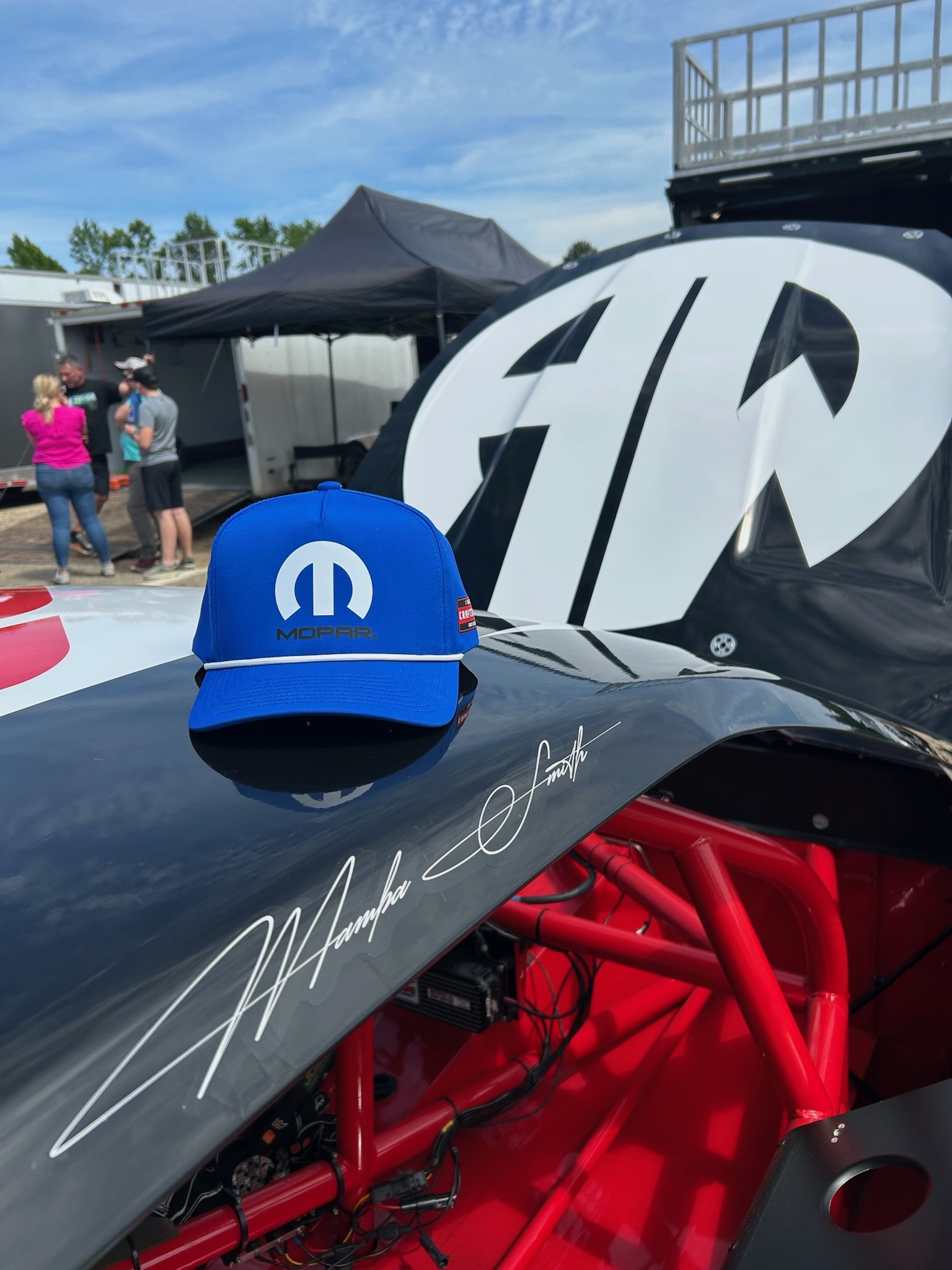 A blue Mopar hat sitting on the open hood of the No. 25, with Dylan 'Mamba' Smith's signature in white script on the deck.