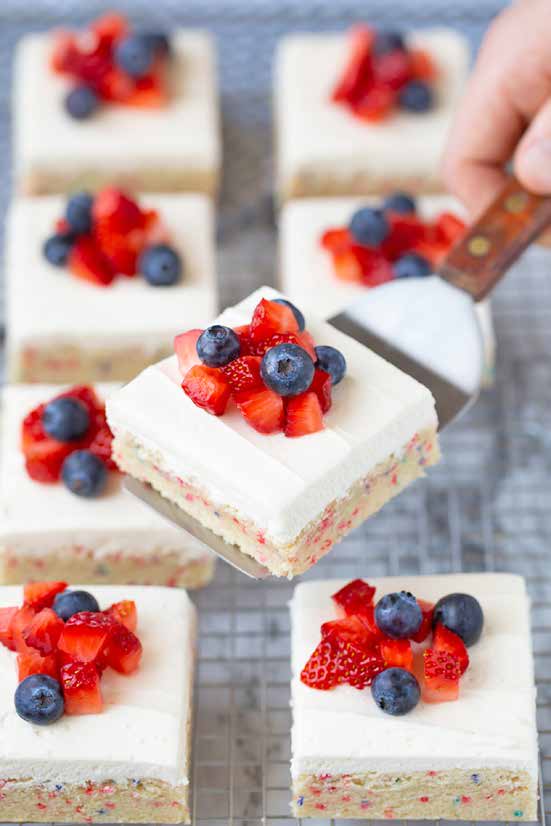 4th of July sugar cookie bars topped with strawberries and blueberries