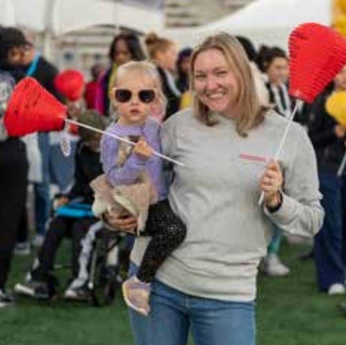 A walker holding a child and a red lantern at Light The Night