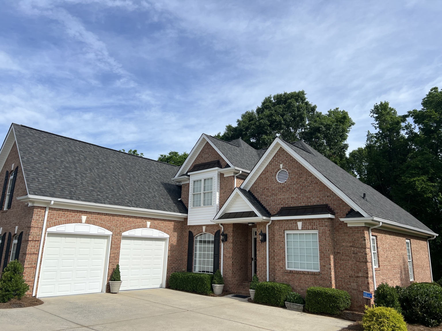 Dark shingle roof on a brick ranch-style home with a two-car garage
