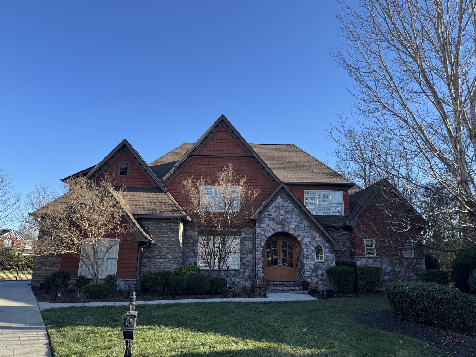 New roof on a stone-and-shake home with multiple gables