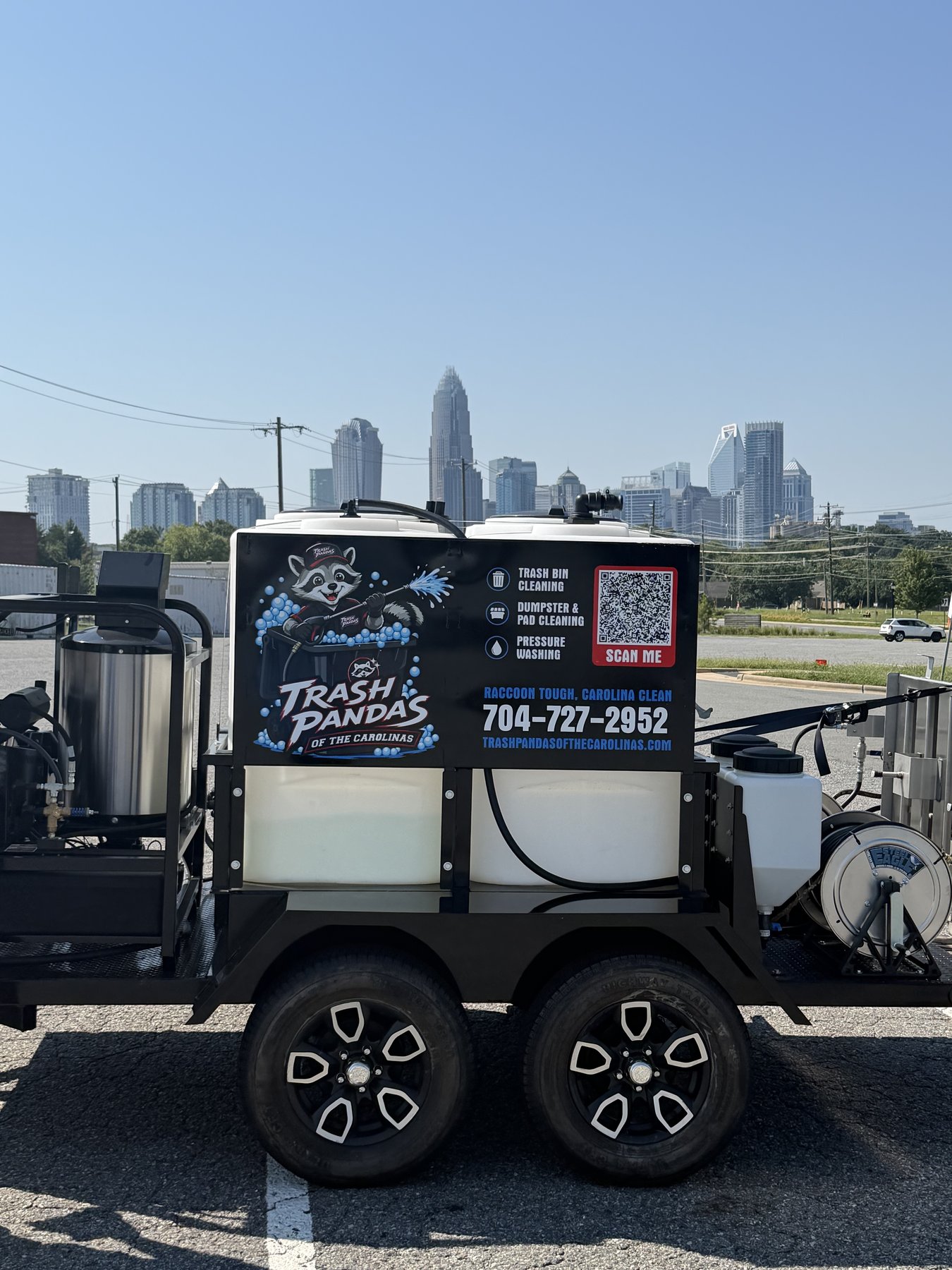 Trash Pandas cleaning trailer with the uptown Charlotte skyline behind it